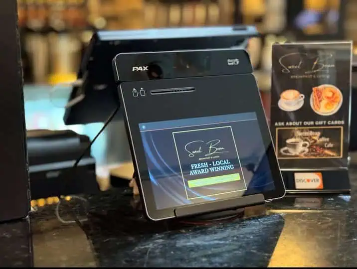 Card Systems PAX POS terminal at a café counter displaying Award-Winning and gift card options.