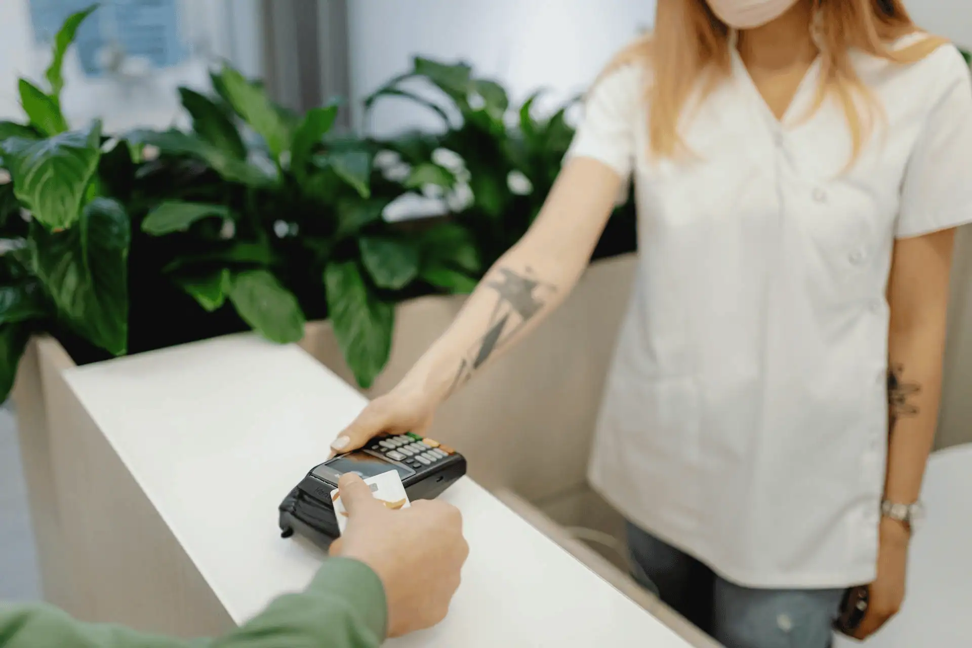 Customer inserts a credit card into a payment terminal at a business counter for secure payment processing.