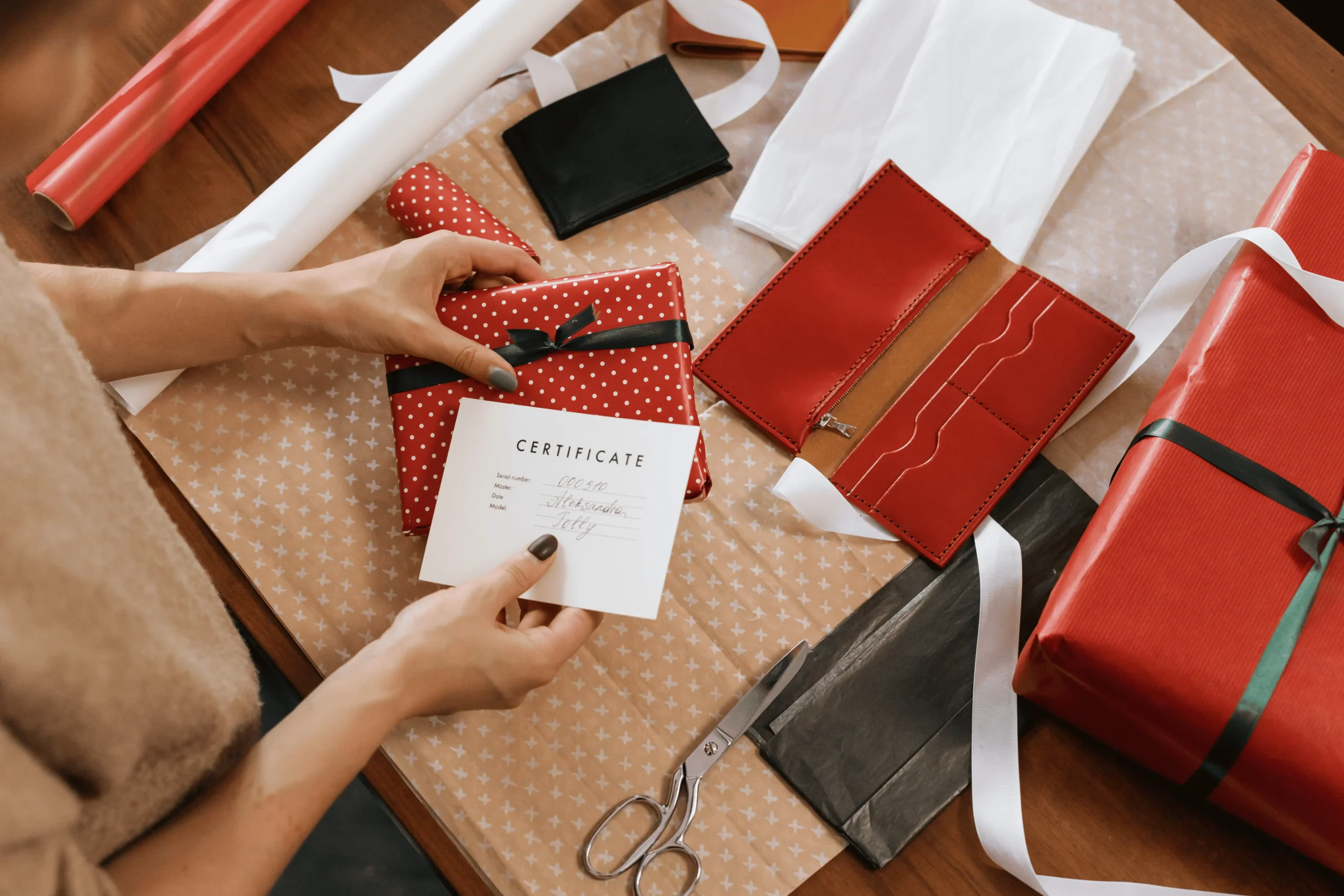 Blank white card beside a small gift box with a red ribbon on a peach background